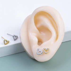 Détail de boucles d'oreilles cœur évidé en argent s925 avec zircons sur modèle d'oreille
