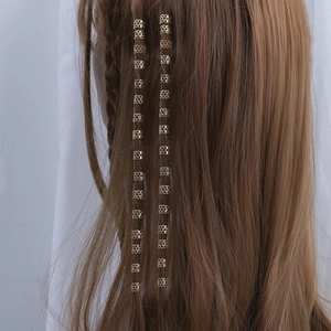 Golden hollow metal hair rings for braids with geometric patterns on brown hair