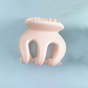 Gros plan sur la mini pince à cheveux rose chair mate avec dents ondulées pour femme