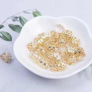 Golden hollow dreadlock rings with infinite pattern displayed in a white heart dish