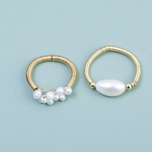 Detail view of handmade gold wire-wrapped rings with natural white pearls set