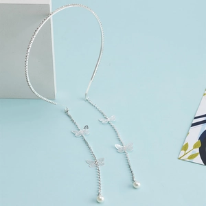 Elegant silver headband with rhinestone bow tassels and pearls on a modern blue background
