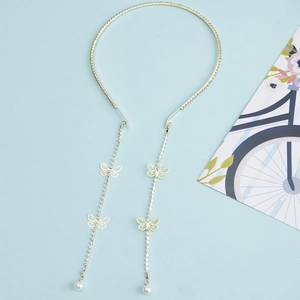 Elegant gold headband with crystal bow, long butterfly tassels, and white pearls on blue base