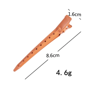 Détail d'une pince à cheveux crocodile rouge rouille de 8,6 cm de long et 1,6 cm de large