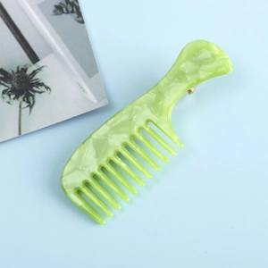 Détail de la pince à cheveux peigne en acétate vert avec texture marbrée et clip doré