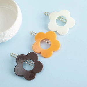 Trois barrettes à fleurs minimalistes en crème, orange et marron avec clip en métal