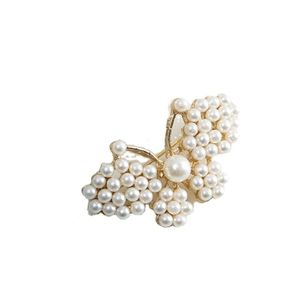 Pince à cheveux papillon dorée élégante avec perles blanches sur fond blanc éclatant