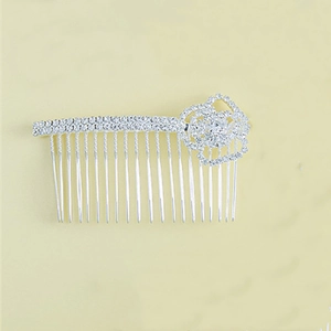 Dettaglio ravvicinato di un pettine per capelli da sposa argentato con rosa di strass