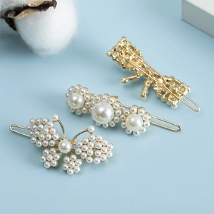 Vue détaillée du lot de barrettes à cheveux dorées avec papillon et perles sur bleu