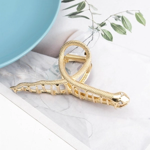Pinza para el pelo de metal dorado con forma de serpiente y textura de escamas