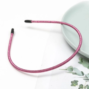 Detail of pink glitter headband with non-slip teeth on a green ceramic plate