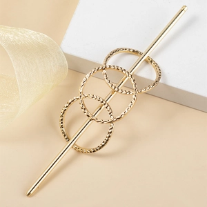Épingle à cheveux minimaliste en métal doré avec cercles géométriques sur fond de soie