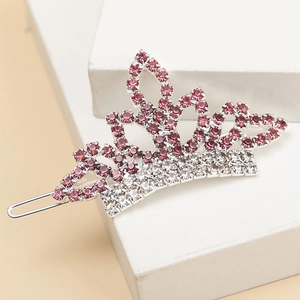 Dettaglio del fermaglio a corona con strass rosa e bianchi su piedistallo di pietra