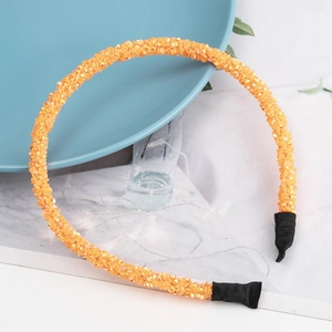 Elegante cerchietto con perline arancioni e cristalli scintillanti su vassoio in ceramica blu