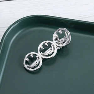 Elegant silver metal hollow smiley face hair clip on a minimalist display tray