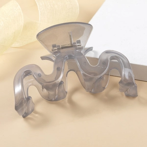 Macro shot of large translucent grey wavy hair claw clip with strong metal spring