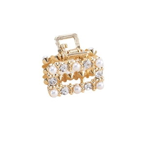 Détail de la mini pince à cheveux dorée ornée de perles blanches et de strass brillants