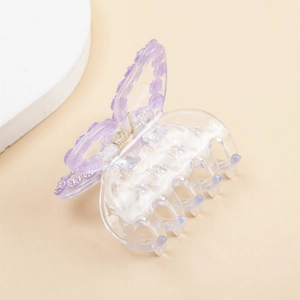 Elegant butterfly hair claw clip with purple rhinestones on a minimalist beige background
