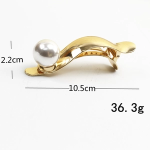 Detailed view of golden hair clip with large pearl showing 10.5cm length measurements