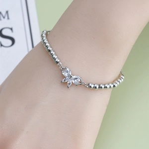 Elegant silver beaded bracelet featuring a delicate bow butterfly charm set with white zircon