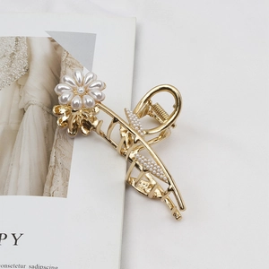 Elegante gouden metalen haarklem met parelbloemen en accenten van kattenoogsteen