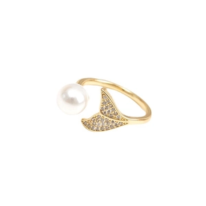 Detail of adjustable gold ring featuring a white pearl and zircon-encrusted mermaid tail