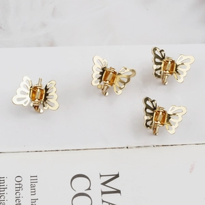 Lot de quatre mini pinces à cheveux papillon dorées en métal poli pour femme