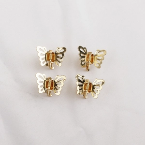 Lot de quatre mini pinces à cheveux papillon dorées avec une finition métallique polie