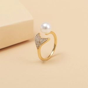 Close-up of golden mermaid tail open ring with a pearl and micro-pave zircons