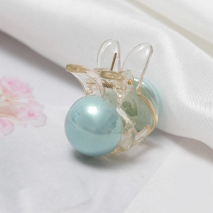 Detalle de la pinza para el pelo de conejo con perlas azul claro y diseño de acrílico
