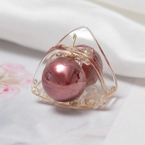 Primer plano de una pinza para el cabello triangular con una perla rosa metálica