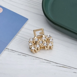 Primer plano de pinza de pelo dorada con brillantes diamantes de imitación blancos