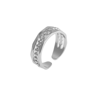 Detail of silver irregular multilayer ring with three zircon stones and beaded edges