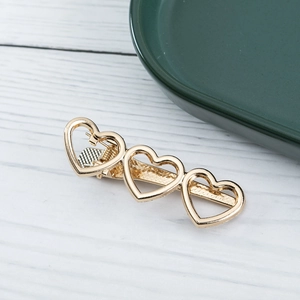 Elegant gold alloy hair clip featuring three hollow heart shapes for a sweet Korean style