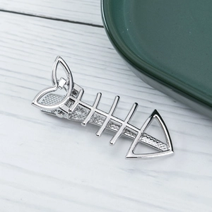 Macro shot of silver metal fishbone hair clip with hollow heart tail and mesh texture