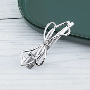Detail of silver alloy bow hair clip with hollow design and anti-slip duckbill clamp