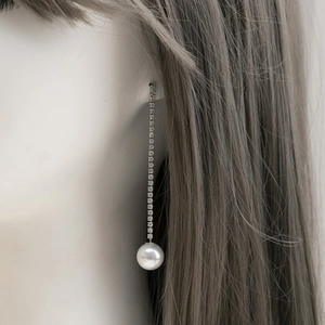 Elegant long tassel earrings with sparkling rhinestones and large white pearls on a model