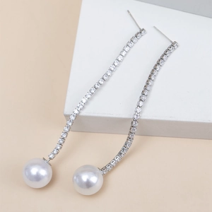 Detail shot of long tassel earrings with sparkling rhinestones and white round pearls
