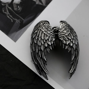 Macro des pendentifs ailes d'ange en acier inoxydable rétro avec texture de plumes