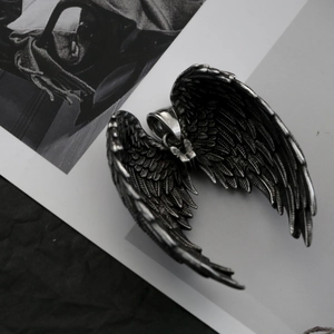 Vue détaillée du pendentif aile d'ange en acier inoxydable avec texture de plumes