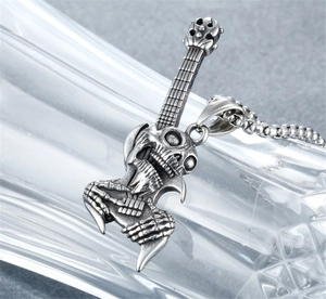 Close-up of punk rock guitar skull pendant with antique finish on silver chain