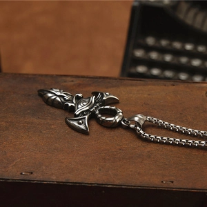Vintage stainless steel Eye of Horus cross necklace for men on a rustic wooden box