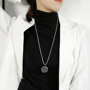 Retro hollow sun pendant necklace on a bead chain styled with a white blazer