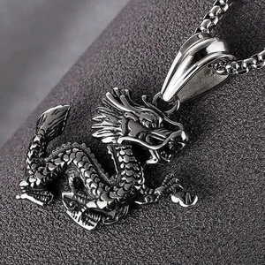 Macro shot of silver dragon pendant with detailed scales and box chain necklace