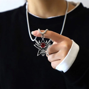 Nahaufnahme von Vintage Edelstahl Anhänger mit rotem Edelstein und Tribalgravur im Gothic-Stil
