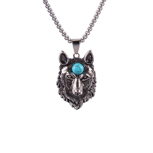 Détail d'un pendentif tête de loup rétro avec pierre bleue et chaîne en acier
