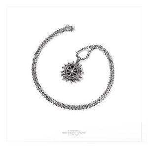 Macro shot of vintage silver Kolovrat sun wheel pendant on a braided steel chain
