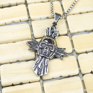 Macro detail of gothic stainless steel skull cross pendant with flame textures