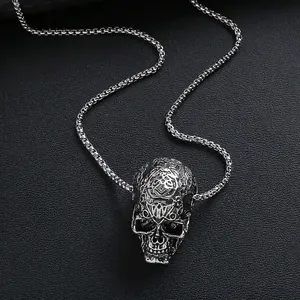 Vintage stainless steel skull necklace with tribal patterns on a textured box chain