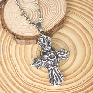 Macro view of punk skull cross pendant with flame texture on vintage wood background